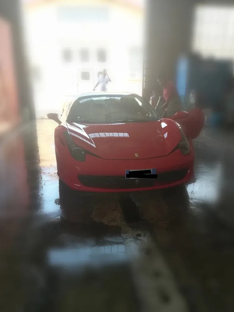 Ferrari 458 rossa nel box durante il lavaggio a mano