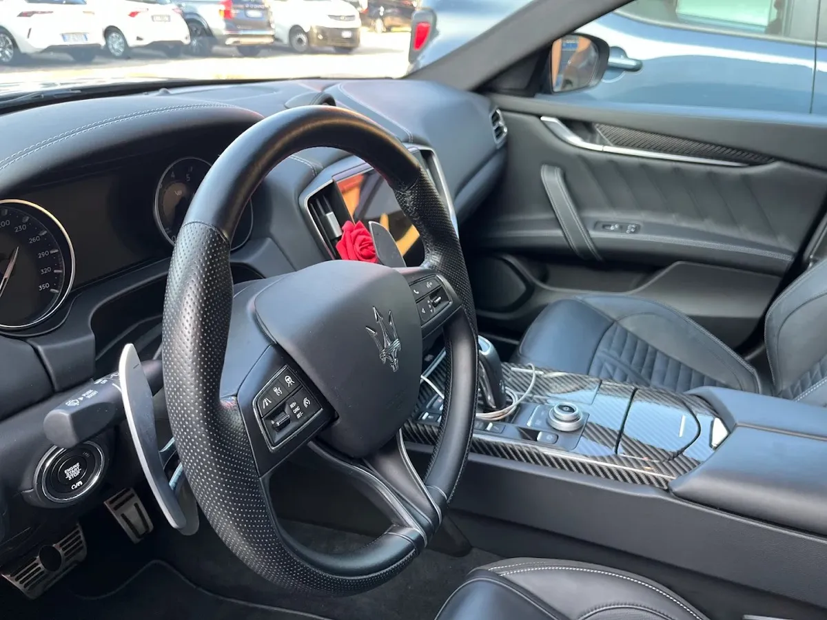 Abitacolo di una Maserati pulito: volante, cruscotto e sedili in pelle